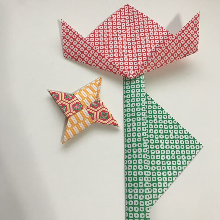 A large paper flower next to a small folded paper star.